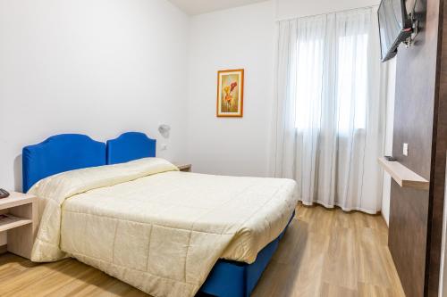 a bedroom with a blue bed and a television at Hotel Cristallo in Riolo Terme