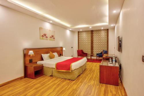 a hotel room with a bed and a desk at Span Inn & Suites - Manali in Baragrān
