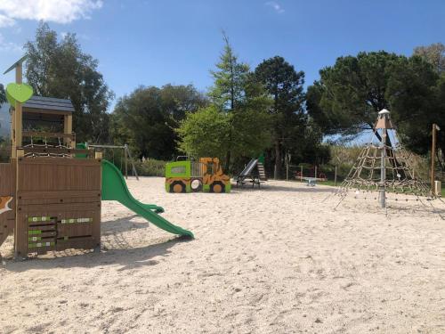 a playground with a green slide and a play equipment at Camping Dolce Vita in Calvi