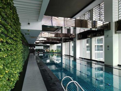 a large swimming pool with chairs in a building at Gramercy Makati Condotel in Manila