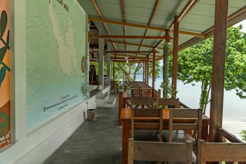 a restaurant with wooden tables and chairs and water at The Hawk's Nest Resort in Sabong