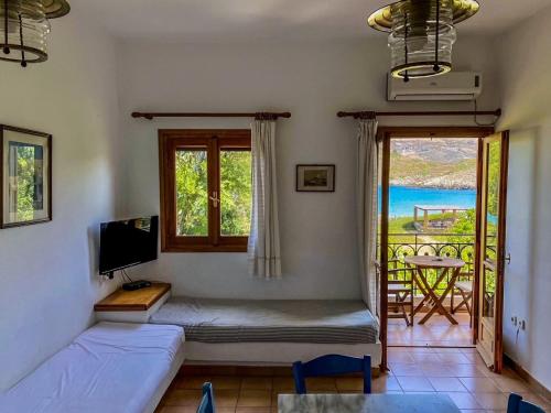 a room with a bed and a window with a balcony at Mealos Apartments in Skiros