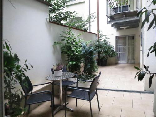 a patio with a table and chairs and plants at Atelier Probst- Salmannsweilergasse in Konstanz