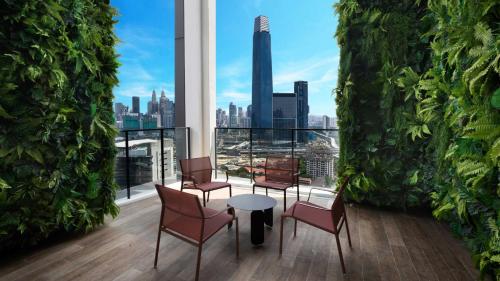 a balcony with chairs and a table and a view of the city at Continew Residence by Shuen in Kuala Lumpur