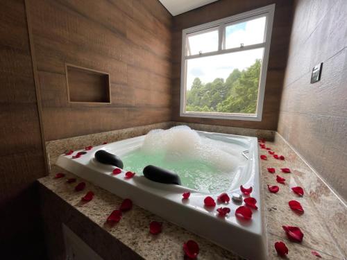 a bathroom with a tub filled with red roses at Champet Boutique Hotel in Campos do Jordão