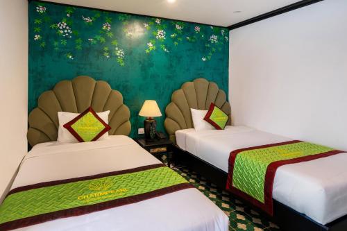 a room with two beds and a green wall at Charmpearl Hotel & Suites in Hanoi