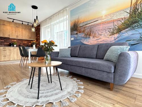 a living room with a couch and a table at Pod Brzozami Apartamenty Gąski in Gąski