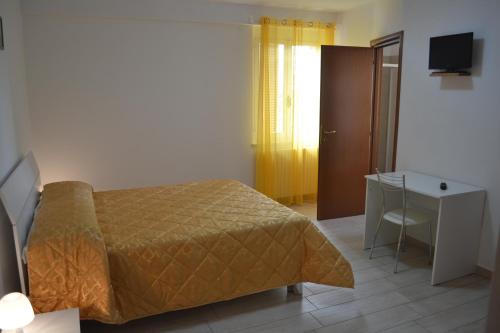 a bedroom with a bed and a desk and a television at Camere I Monelli in Assisi