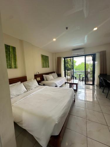 a hotel room with two beds and a balcony at Fernando's Hotel in Sorsogon