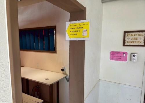 a sign on the door of a hospital room at Auberge Ninguruforet in Biei
