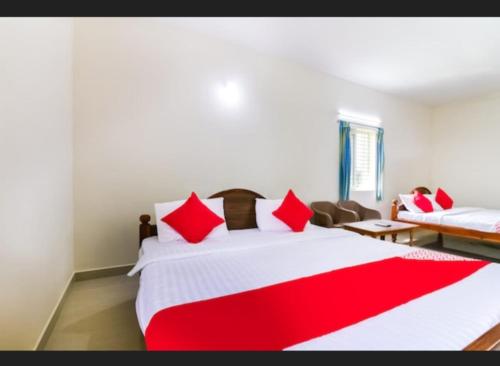 a bedroom with a large bed with red pillows at R S RESIDENCY (Thalapaneni Pavan Kalyan) in Nagari