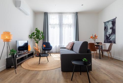 a living room with a couch and a tv at Home 10 min from efteling and university in Tilburg