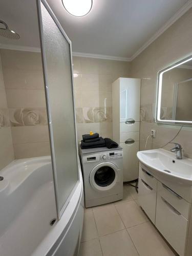 a bathroom with a washing machine and a sink at 2-к квартира в ЖК Андріївський Центр in Ternopilʼ
