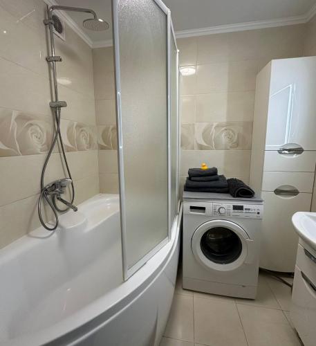a bathroom with a shower and a washing machine at 2-к квартира в ЖК Андріївський Центр in Ternopilʼ