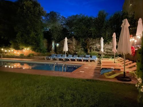 a pool with chairs and umbrellas at night at Sant Grau ii in Navés