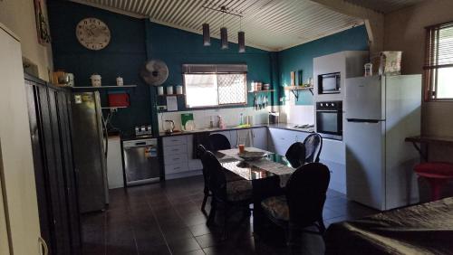 a kitchen with a table and a white refrigerator at Linga Longa Spiritual Retreat in Curra