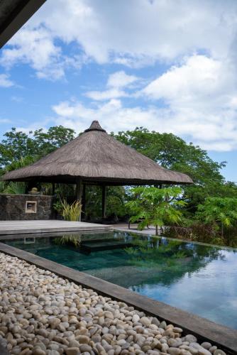 a swimming pool with a gazebo and water at Luxury Villa in le Morne in Le Morne
