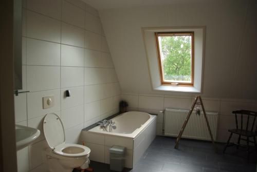 W łazience znajduje się toaleta, wanna i umywalka. w obiekcie B&B Noflik Haule w mieście Haule