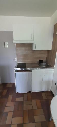 une cuisine avec des armoires blanches et un comptoir dans l'établissement T2 Saint Palais sur mer, 500 m plage Nauzan, Résidence Cap Atlantic, à Saint-Palais-sur-Mer