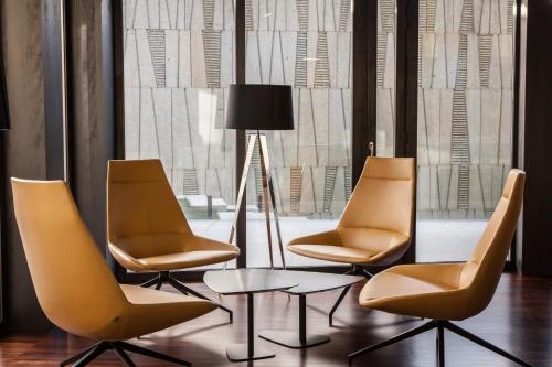 three chairs and a table in front of a window at Pousada Armenteira in Pontevedra