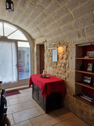 une pièce avec une table avec une nappe rouge dans l'établissement Maison Chêne Vert, à Sanilhac-et-Sagriès