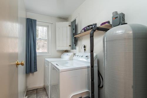 a small kitchen with a washing machine and a sink at Bear Hill Cabin cabin in Ludlow