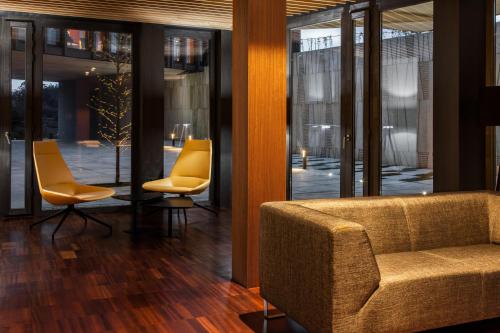 a lobby with a couch and chairs and windows at Pousada Armenteira in Pontevedra