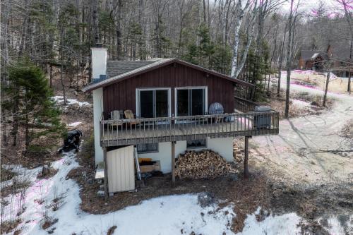a cabin in the woods with a deck at Bear Hill Cabin cabin in Ludlow