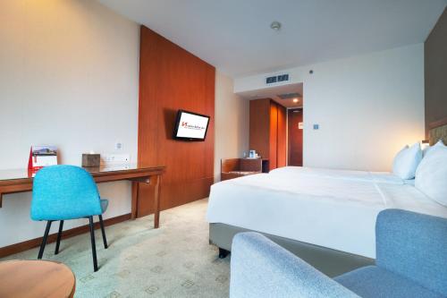 a hotel room with a bed and a desk at Swiss-Belinn SKA Pekanbaru in Pekanbaru