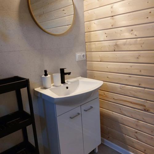 a bathroom with a white sink and a mirror at Domki Północ-Południe in Karwia