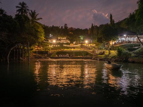 a boat in a river at night with lights at The Hawk's Nest Resort in Sabong