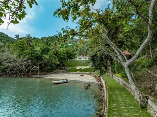 a boat in the water next to a beach at The Hawk's Nest Resort in Sabong
