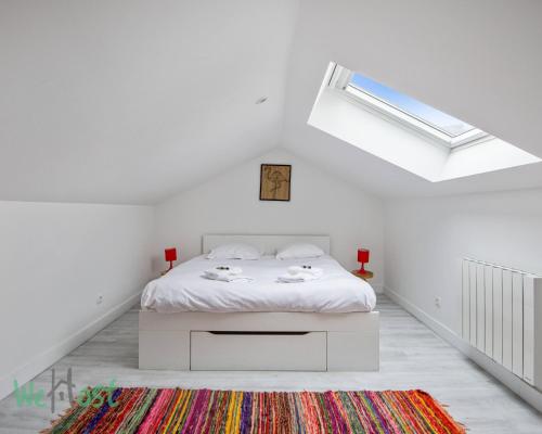 - une chambre blanche avec un lit et une lucarne dans l'établissement Daisy-Stations,Grd Palais,Zénith&Center, à Lille