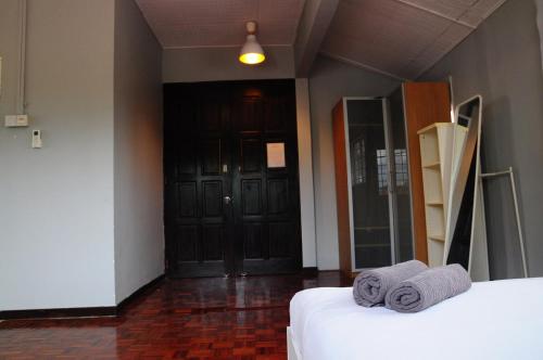 una camera con un letto e una porta con asciugamani di GRAYHAUS Spacious Bungalow & Garden Villa - SS3 Petaling Jaya, near Sunway - Stay Only NO EVENTS a Petaling Jaya