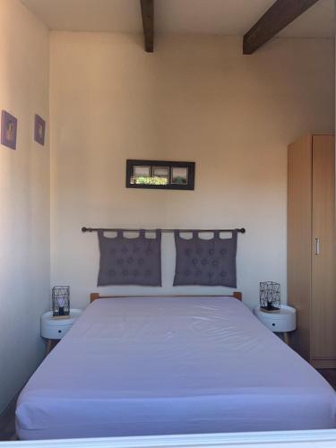 une chambre avec un grand lit avec deux tables de nuit dans l'établissement Charmante maison avec sa terrasse au soleil, au Cap d'Agde