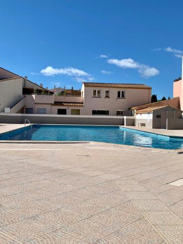 une piscine devant un immeuble dans l'établissement Charmante maison avec sa terrasse au soleil, au Cap d'Agde