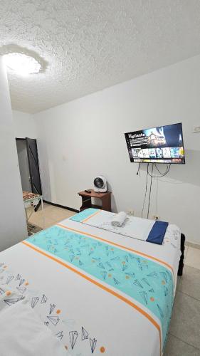 カリにあるMom's house Colombia Casa 1のベッドが2つと壁にテレビがある部屋