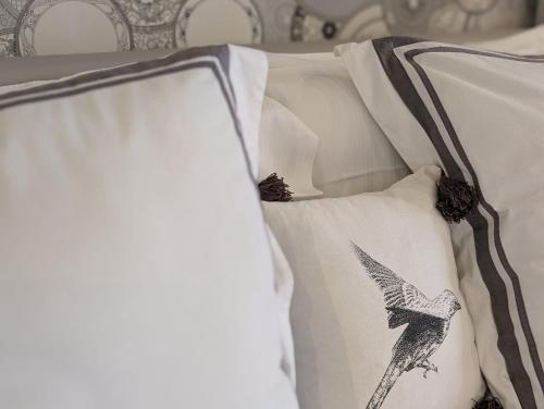 a bed with white pillows with a bird on it at Vernazza Luxury Apartment in Vernazza