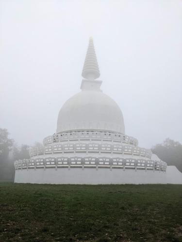 a large white building in the fog with a large buddhist temple at Ház a Hold utcában in Kehidakustány