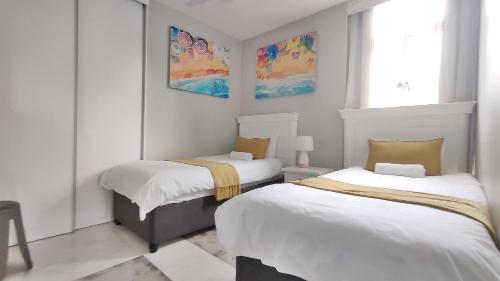 ein Schlafzimmer mit zwei Betten und einem Fenster in der Unterkunft La Ballito 107 in Ballito