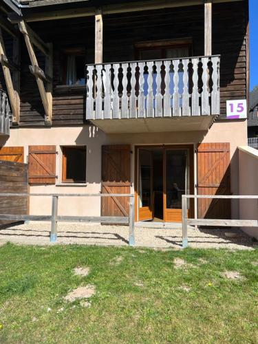 une maison avec un balcon et un portail dans l'établissement Super Besse chez Sophie 2ch, séjour, wifi, 2tv, rdc, terrasse, parc, piscine, pkg, à Besse-et-Saint-Anastaise