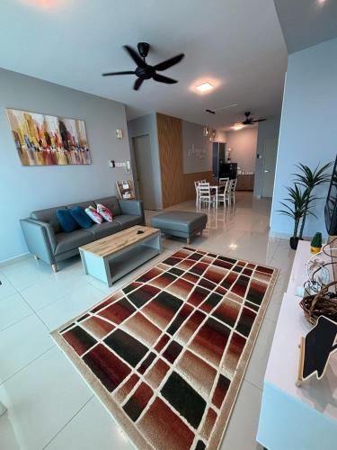 a living room with a couch and a ceiling fan at Anggerik Homestay - Palm Garden Apartment in Lahad Datu