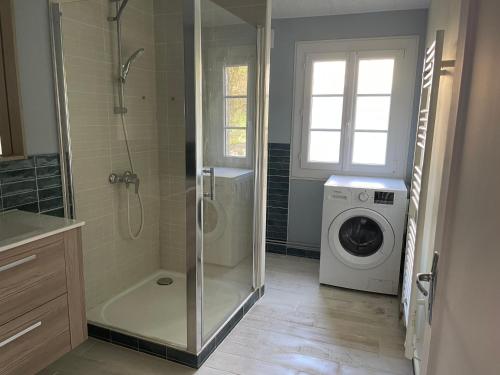 une salle de bain avec douche et machine à laver dans l'établissement Centre de bien-être Naturéau avec massages et soins, à Chalandray