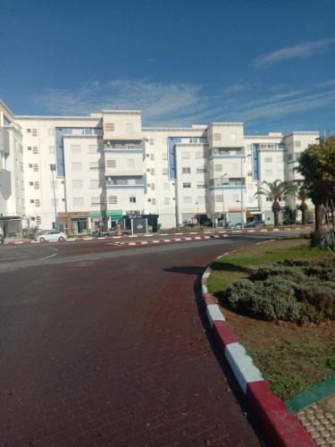 una calle vacía frente a un gran edificio en BOUZNIKA Appartement au Centre ville, en Bouznika