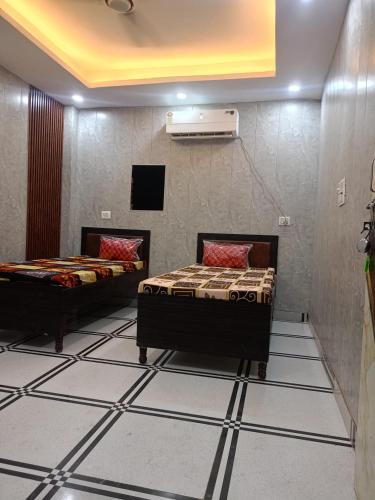 two beds in a room with tiled floors at Royal Stone Hotel in Noida