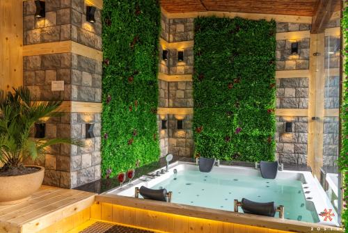 a spa tub with a green wall with plants at Zostel Plus Kareri in Dharamshala
