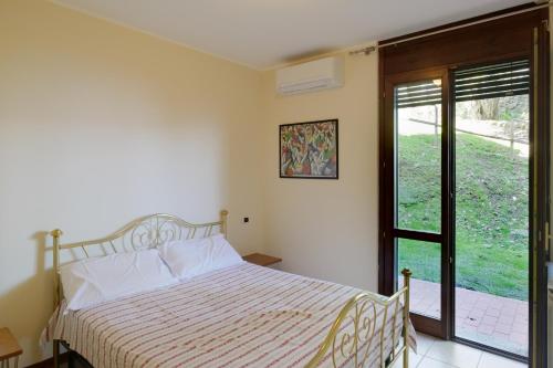 a bedroom with a bed and a sliding glass door at Verde Acqua in Stresa