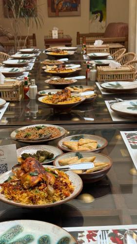 a long buffet of plates of food on a table at Al Koot Heritage Hotel in Al Hofuf