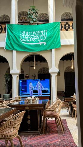 a flag hanging above a table in a room with chairs at Al Koot Heritage Hotel in Al Hofuf