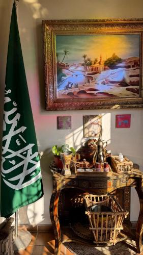 a table with a flag and a painting on the wall at Al Koot Heritage Hotel in Al Hofuf